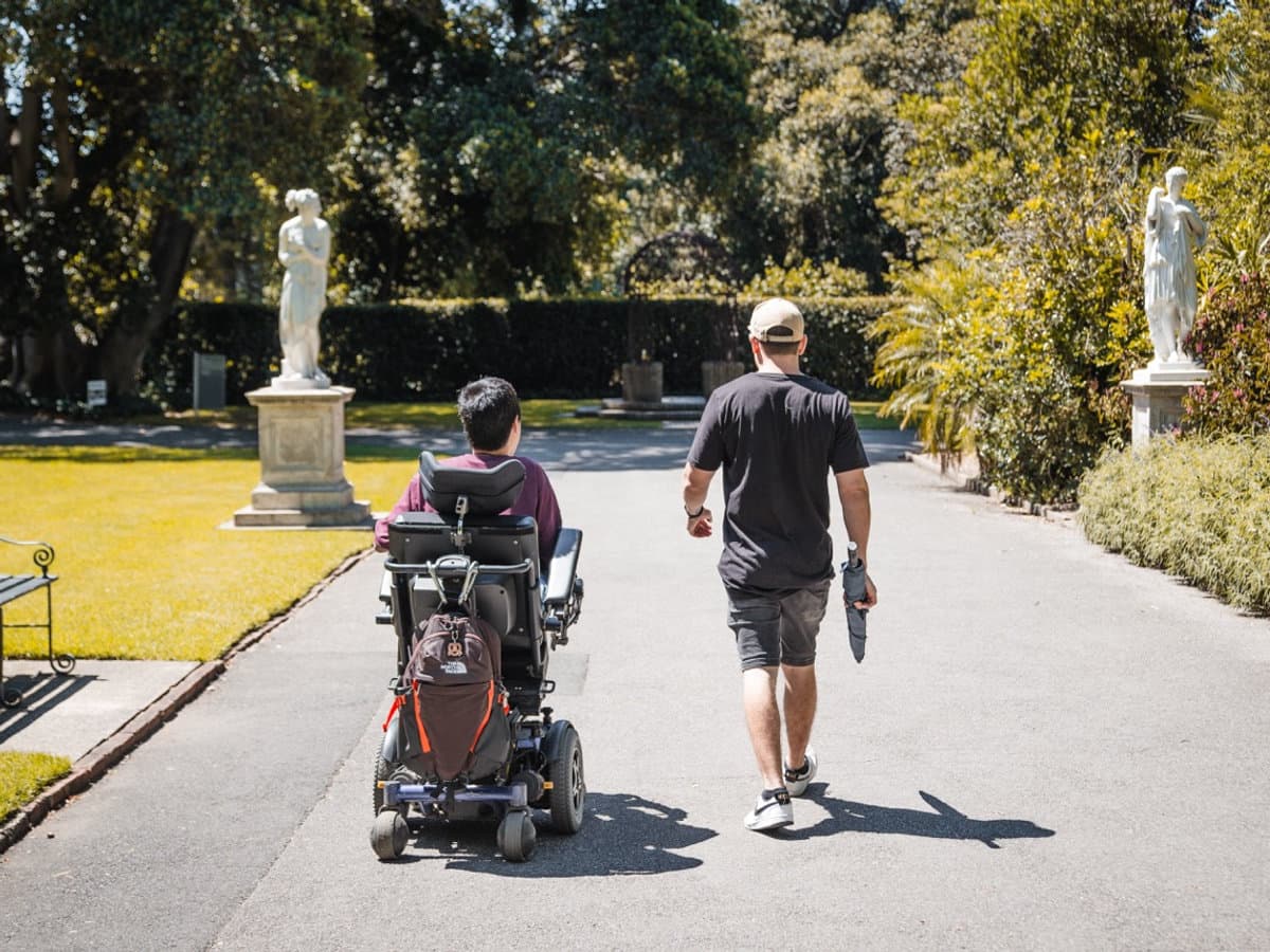 Support worker and young adult enjoying community recreation outdoors